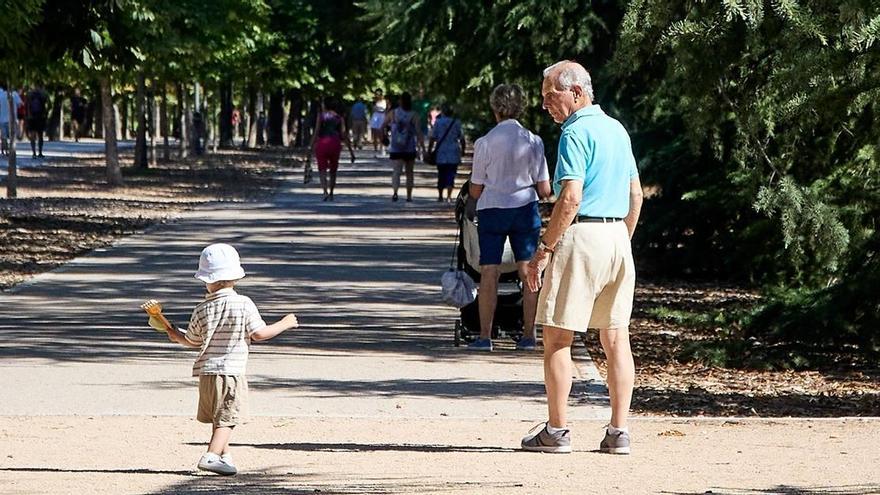 Un abuelo cuida de su nieto en un parque.