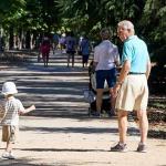 Un abuelo cuida de su nieto en un parque.