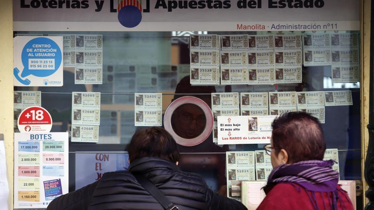 Varias personas compran décimos de la Lotería de Navidad 2024 a pocos días del sorteo.