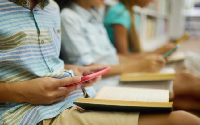 Varios menores con sus 'smartphones' en el colegio. Varios menores con sus 'smartphones' en el colegio.