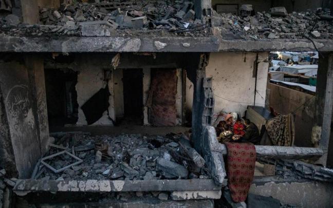 Una familia rompe el ayuno del ramadán entre los escombros de su vivienda.