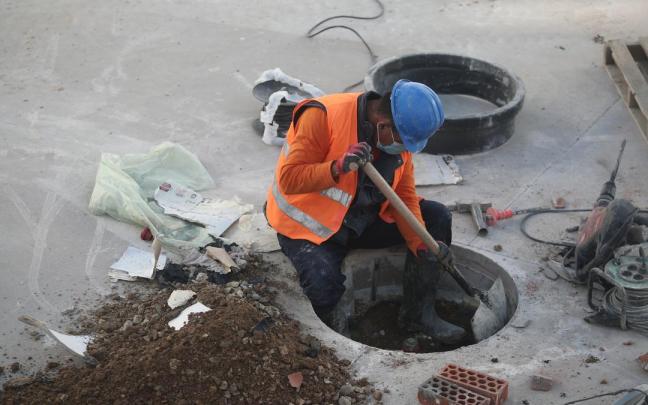 Un obrero trabaja en una alcantarilla.
