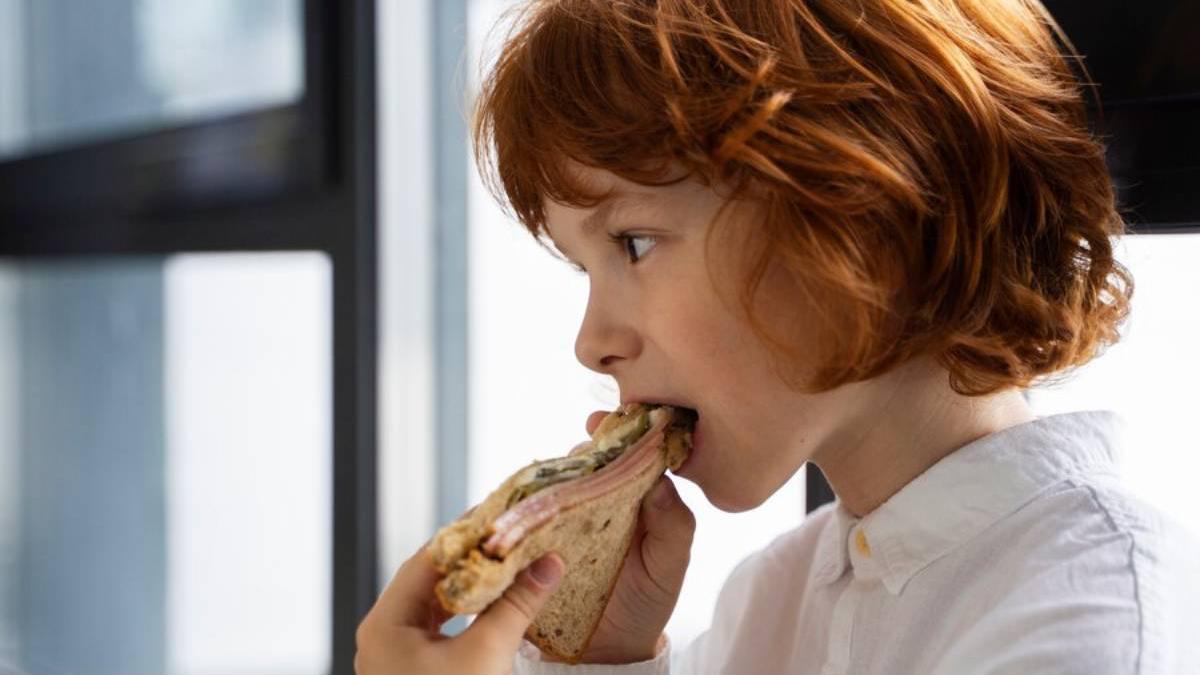 Niño comiendo un sándwich