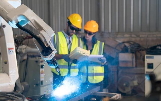 Un brazo robótico desempeña su labor en una fábrica.