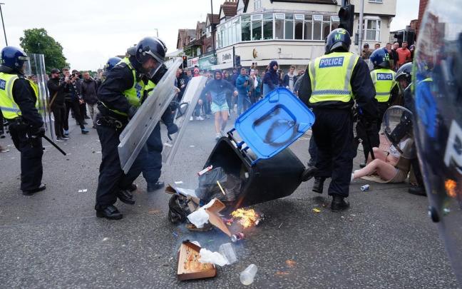Un grupo de personas lanza un cubo de basura a la policía británica durante los disturbios en Middlesbrough, Reino Unido, en 2024. / EP Un grupo de personas lanza un cubo de basura a la policía británica durante los disturbios en Middlesbrough, Reino Unido, en 2024.