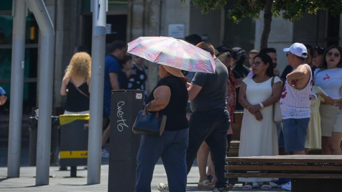 Una mujer se protege del sol con un paraguas en plena ola de calor en Gasteiz.