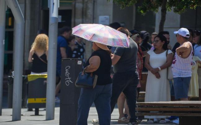 Una mujer se protege del sol con un paraguas en plena ola de calor en Gasteiz.