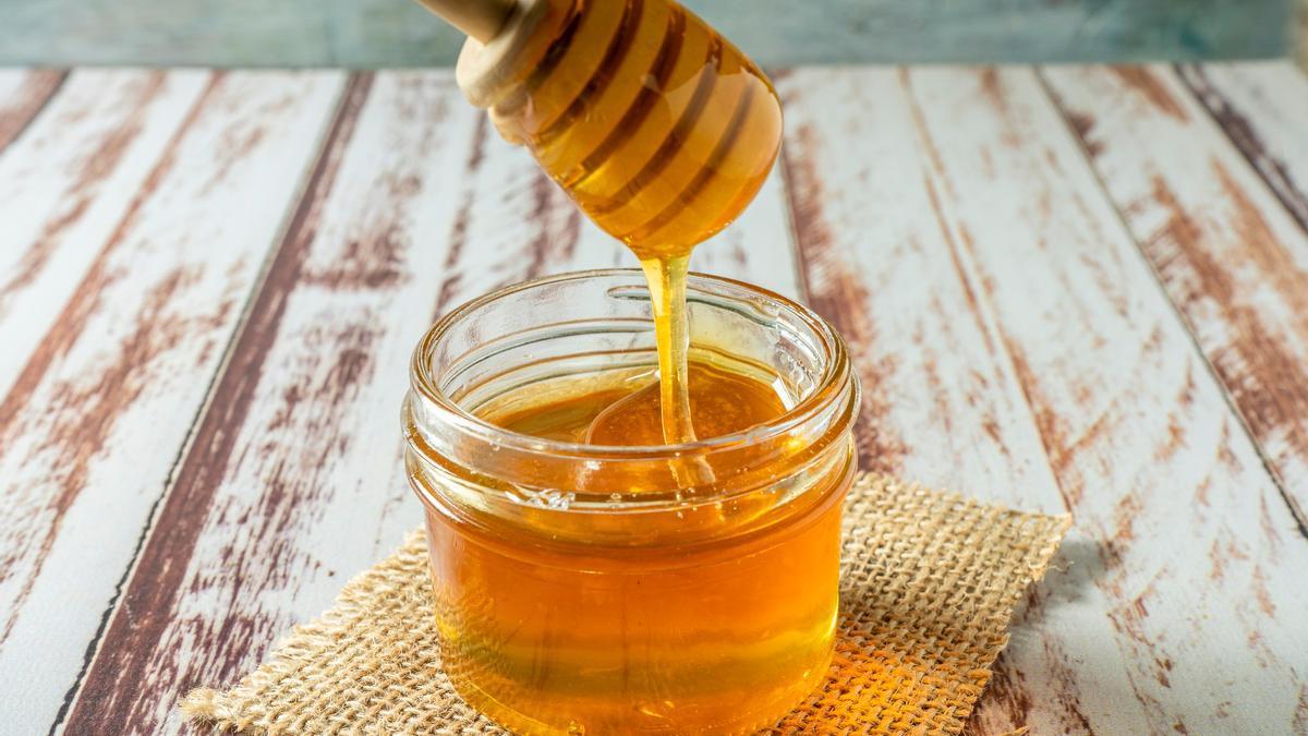 Un tarro pequeño de cristal con miel.