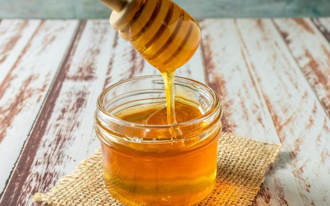 Un tarro pequeño de cristal con miel.