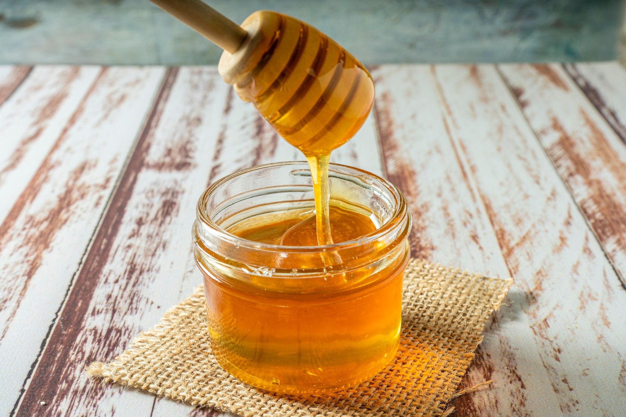 Un tarro pequeño de cristal con miel.