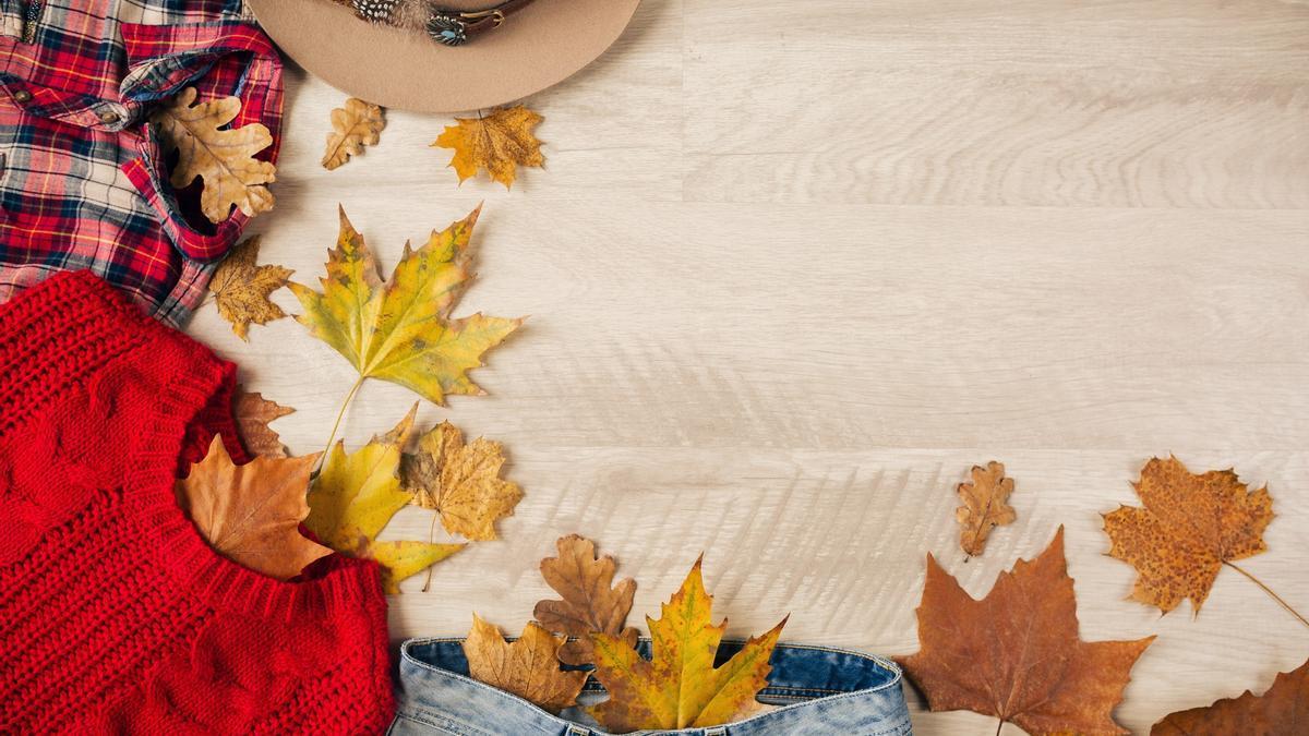 Ropa de otoño sobre una mesa con hojas..