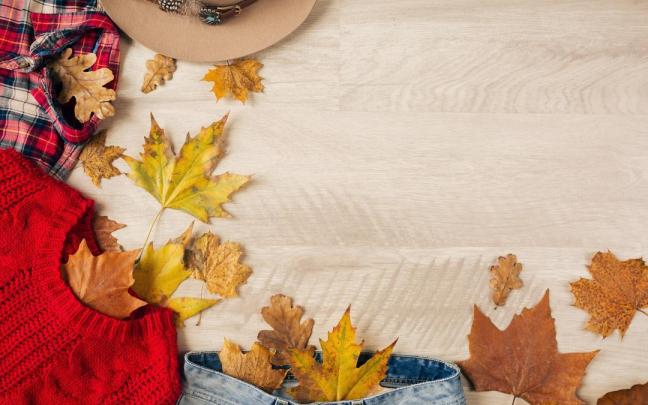 Ropa de otoño sobre una mesa con hojas..