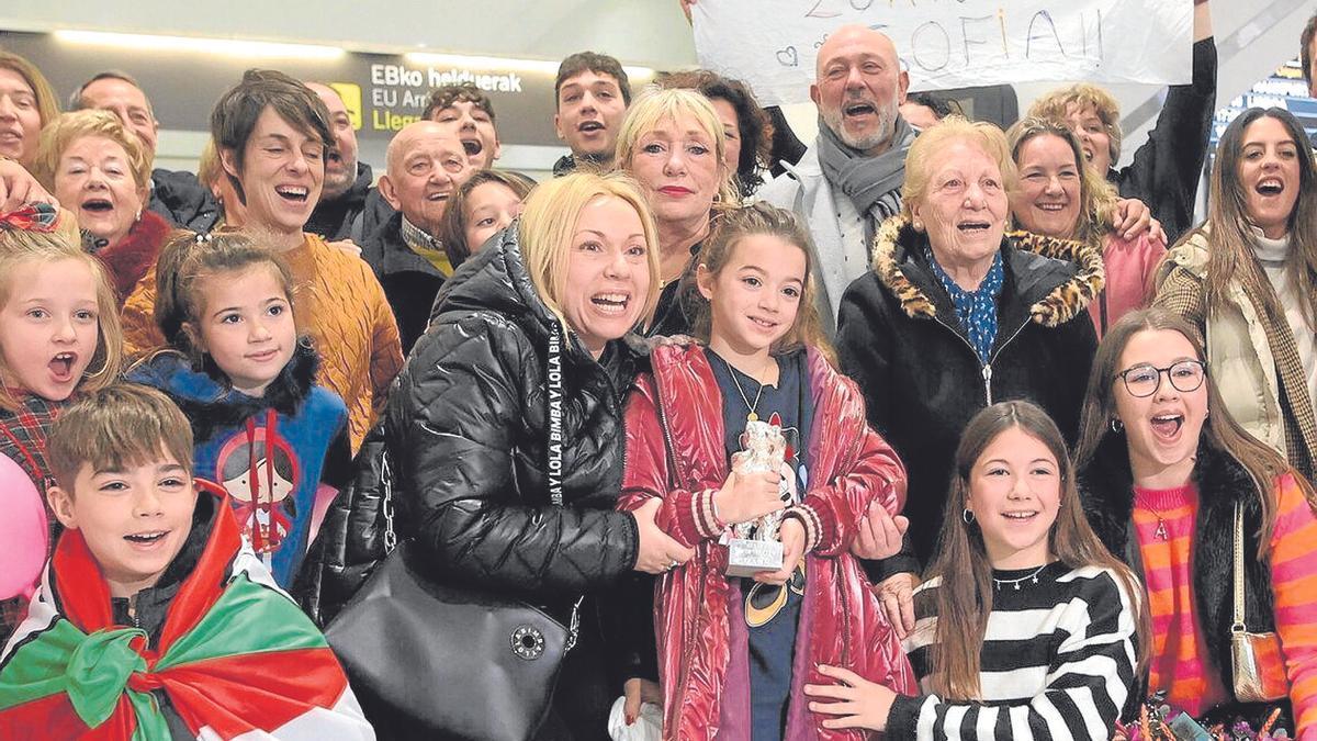 La pequeña Sofía Otero, en el centro de la imagen, flanqueada por familiares y amigos a su llegada a ‘La Paloma’, y acompañada por la directora Estibaliz Urresola. | FOTO: BORJA GUERRERO