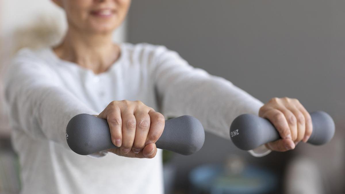 Mujer realiza ejercicios con pesas.