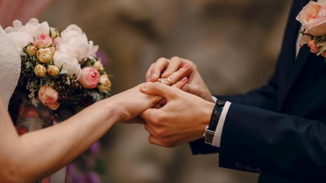 El novio coloca la alianza a la novia durante la ceremonia.
