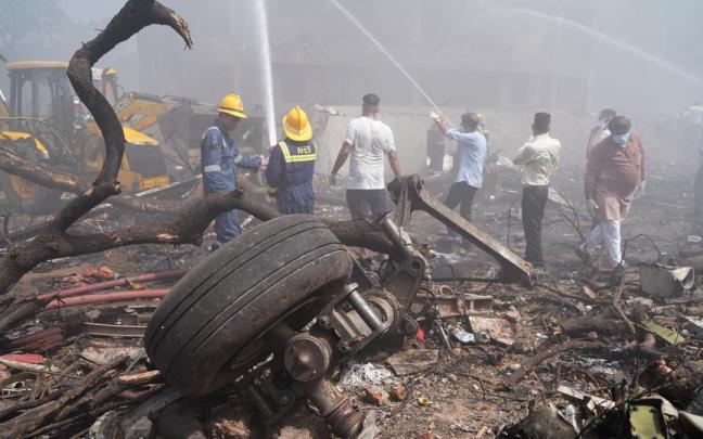 Servicios de emergencia y voluntarios en el lugar del accidente en Gujarat.
