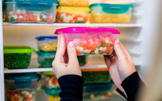 Mujer guarda un taper con verduras en la nevera / Freepik Mujer guarda un taper con verduras en la nevera
