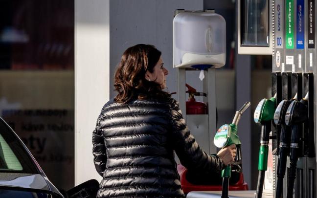 Una mujer reposta en una gasolinera.