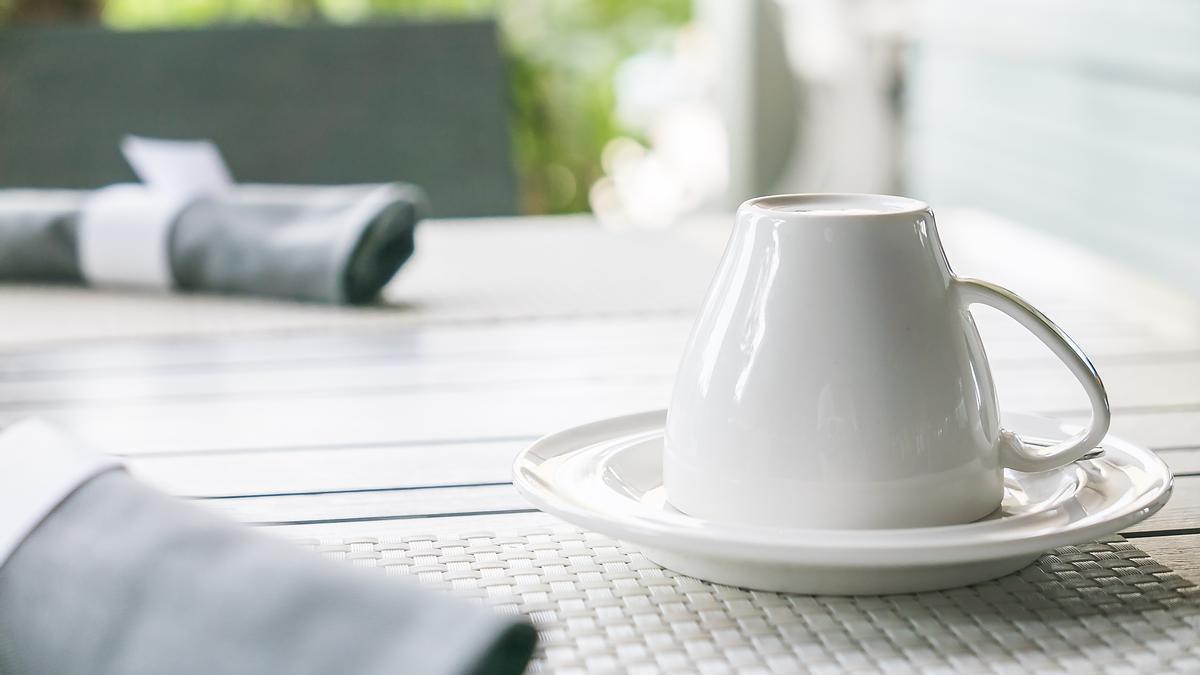 Taza boca abajo en una mesa preparada para comer en el exterior de casa