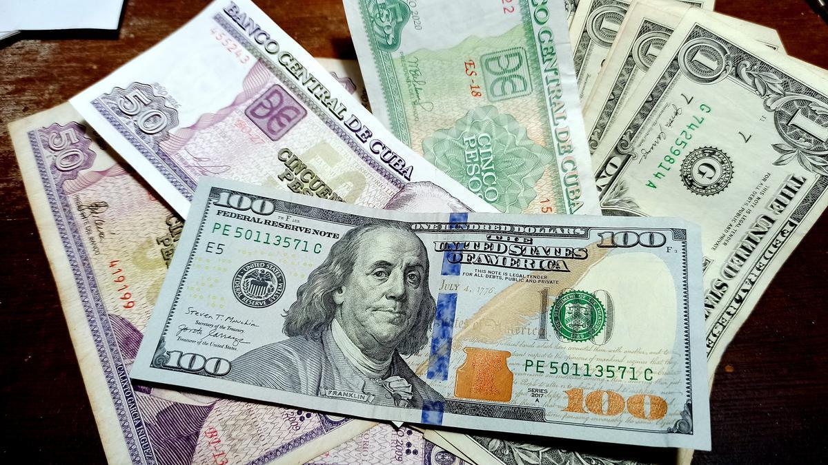 Billetes de dólar junto a otros de peso cubano.