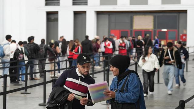 Una mujer revisa sus papeles en el pabellón 2 del recinto de Montjuïc de Fira de Barcelona.