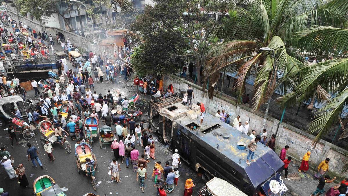 Ciudadanos de Bangladesh frente a una comisaría en Daca tras la dimisión de la primera ministra, Sheij Hasina