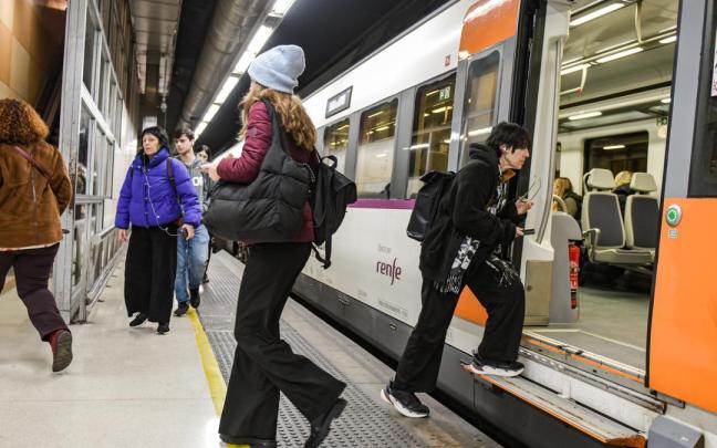 Viajeros cogen un tren de Rodalies en la estacion de Sants en Barcelona