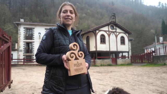 Maitane posa con el premio Landaola con la pequeña iglesia de Lastur al fondo.