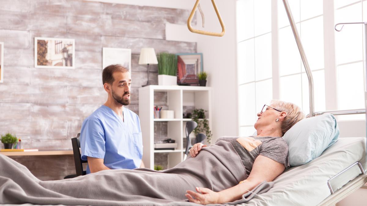 Un fisioterapeuta dialoga con una paciente para conocer su estado de salud.