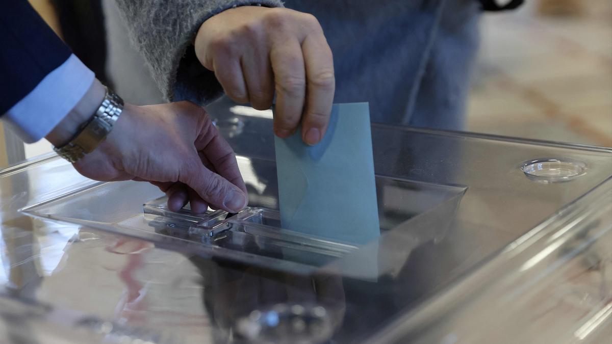 Imagen de archivo de una persona introduciendo un voto en una urna.
