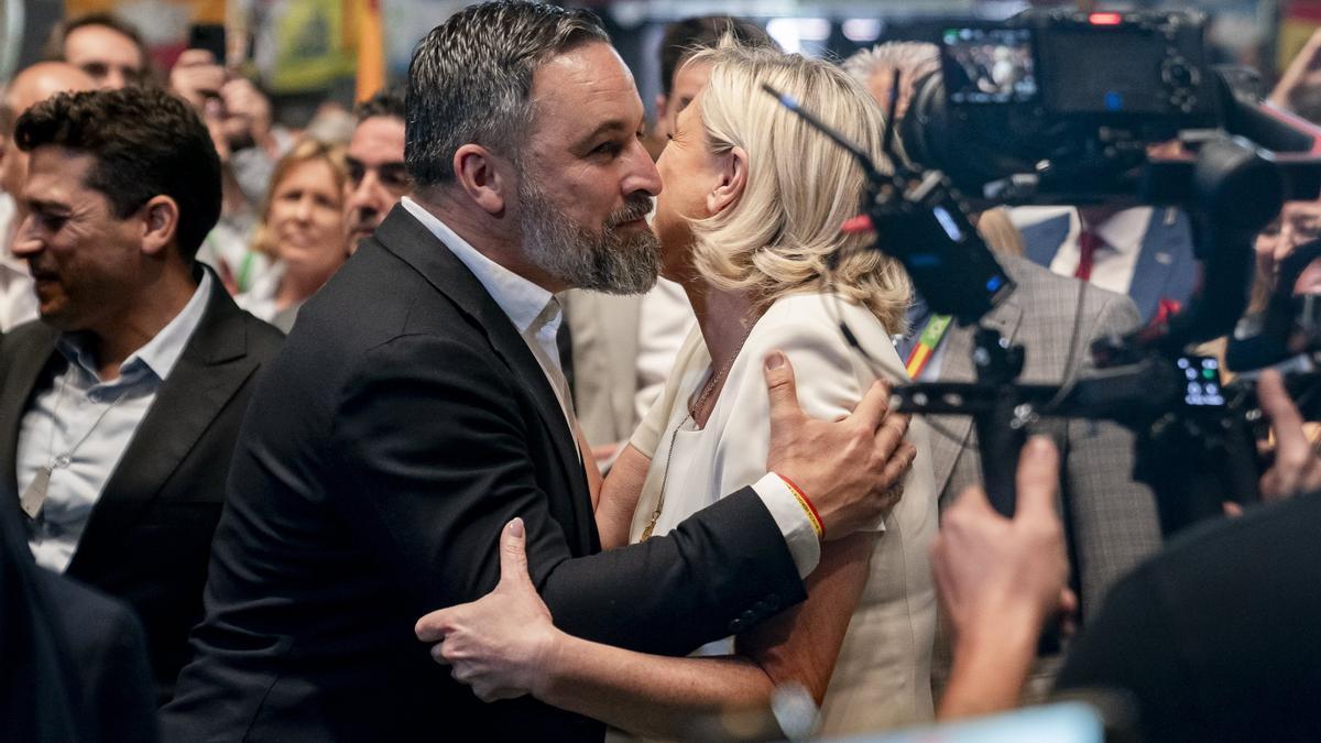 Santiago Abascal saluda a Marine Le Pen este domingo en el acto de Vox en Madrid.