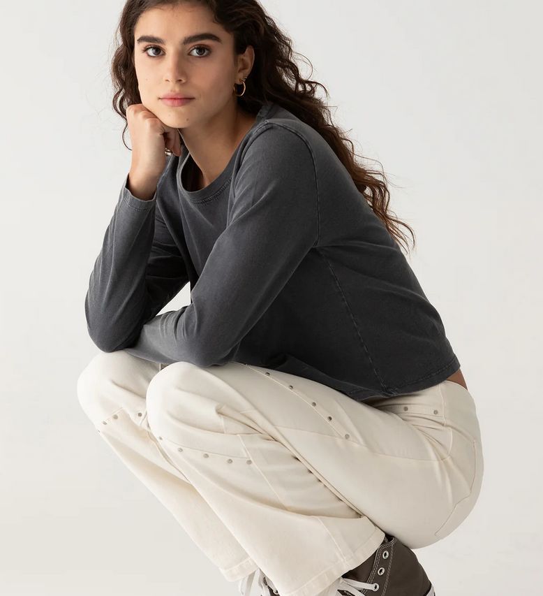 Pantalón blanco decorado con tachuelas.