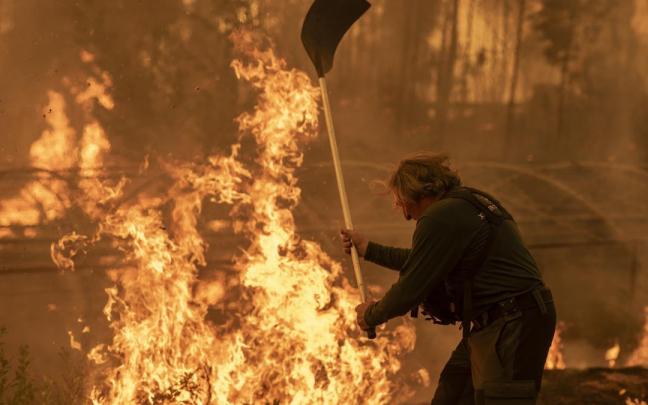 Un vecino trata de contener un fuego en Carballeda de Avia, Ourense.