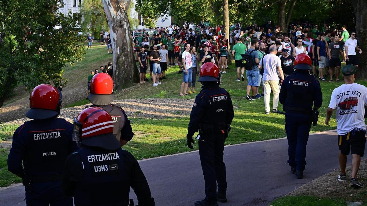 Agentes de la Ertzaintza frente a un grupo de personas durante los altercados registrados en Bilbao el día de la Final del Mundial de Fútbol entre Argentina y España