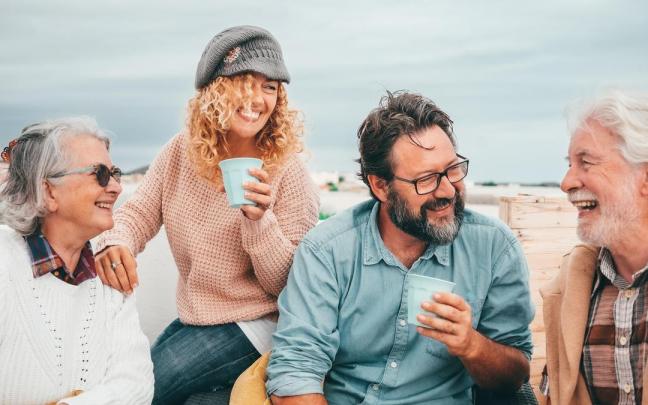 Cuatro amigos comparten confidencias en una terraza.