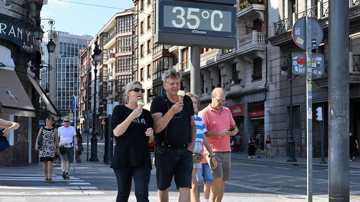 Dos personas hacen frente a una ola de calor en Bilbao comiéndose un helado.