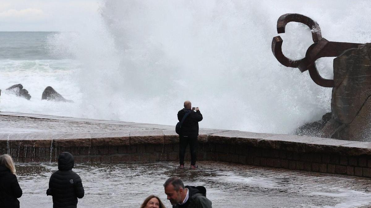 Turistas en el Peine del Viento viendo el oleaje.