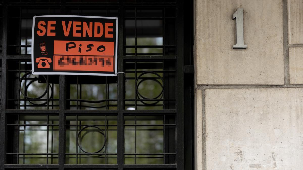 Vista de un cartel de 'Se vende' en un portal de un edificio.