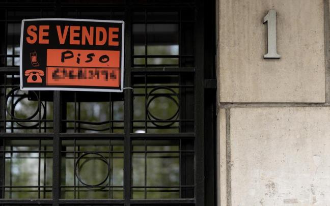 Vista de un cartel de 'Se vende' en un portal de un edificio.