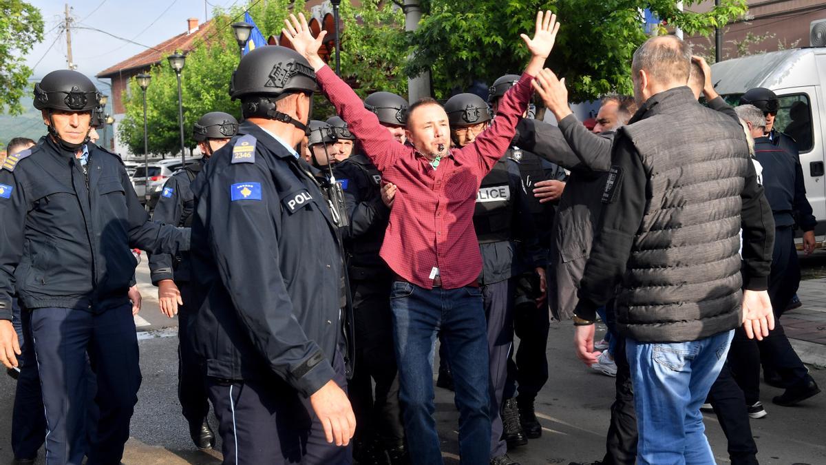 La policía kosovar trata de impedir el paso a un grupo de ciudadanos serbios a las puertas de un edificio en Zvecan.