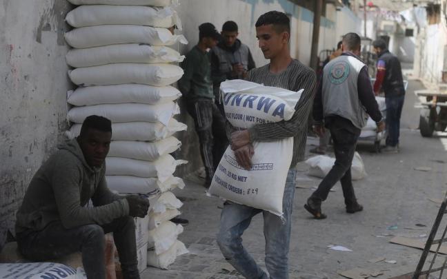 Foto de archivo de un trabajador palestino cargando un saco de harina de la Agencia de la ONU para los refugiados de Palestina.