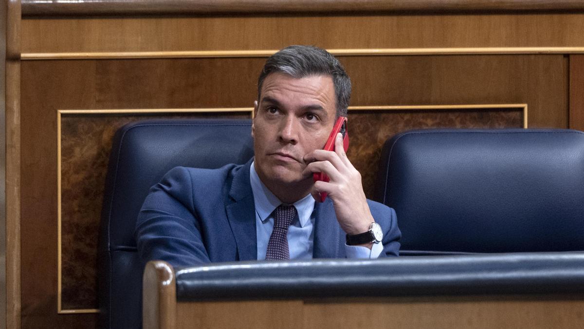 El presidente del Gobierno español, Pedro Sánchez, utiliza su teléfono móvil en un pleno del Congreso
