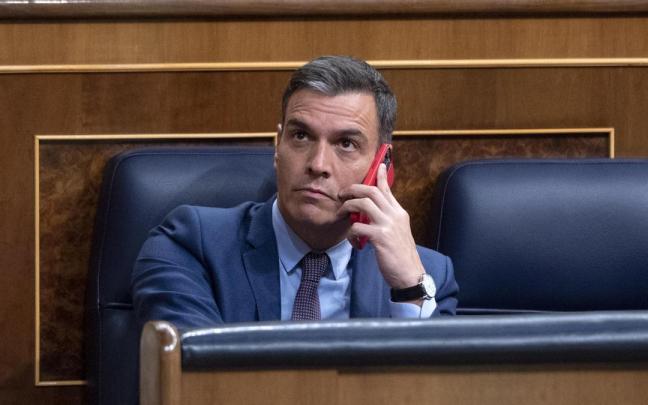 El presidente del Gobierno español, Pedro Sánchez, utiliza su teléfono móvil en un pleno del Congreso