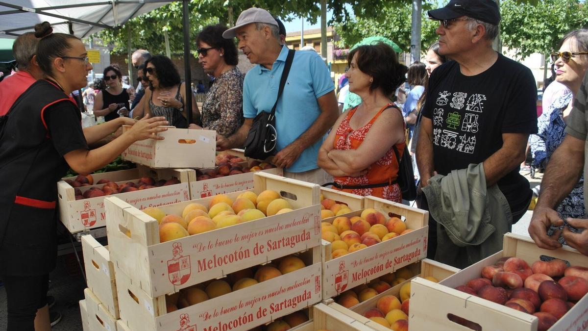 Gente comprando barquillas de melocotones en la Feria del Melocotón en Sartaguda.