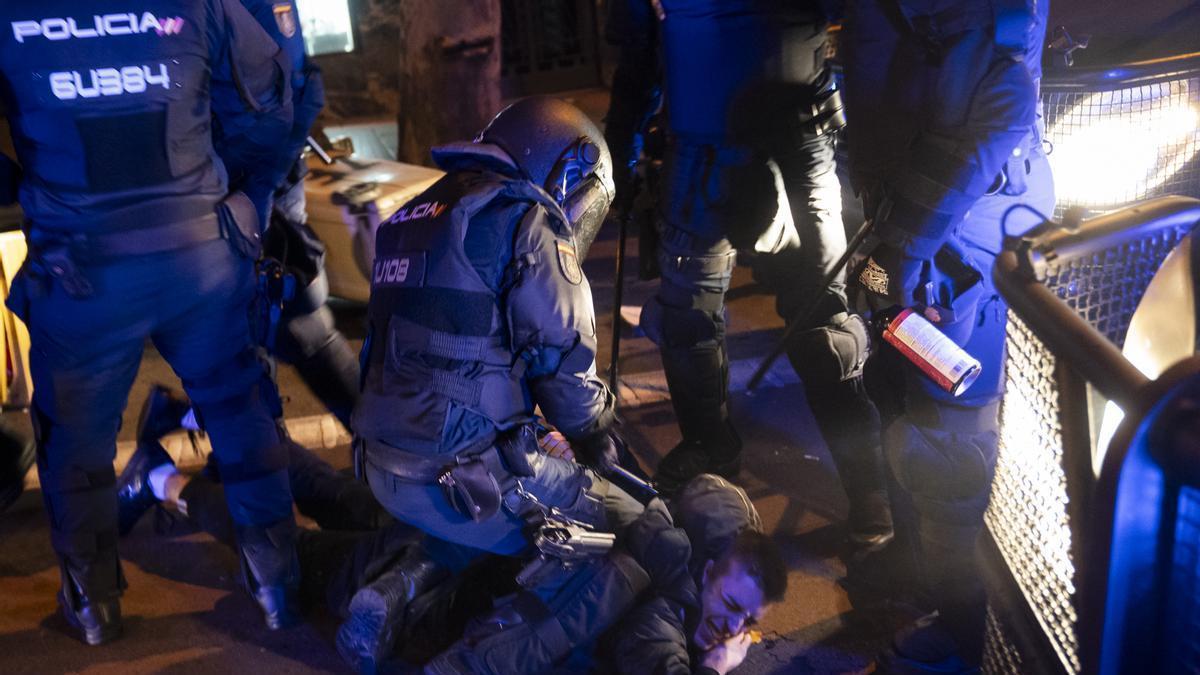 Varios agentes de policía detienen a un manifestante, durante una manifestación contra la amnistía frente a la sede del PSOE en Ferraz.