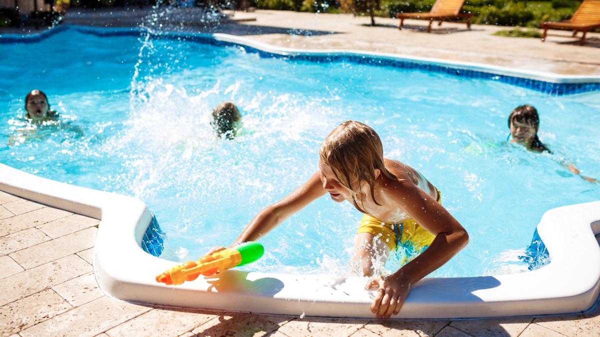 Niños jugando en una piscina.
