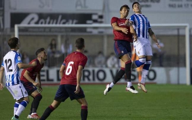 Martín Merquelanz salta con un jugador de Osasuna en un amistoso en Irun. / UNAI BEROIZ