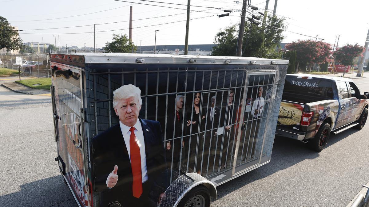 Un seguidor de Trump remolca una 'celda' de candidatos demócratas ante la prisión en la que se entregará el expresidente republicano.