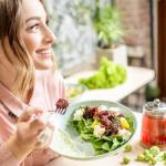 Chica sonriente come un plato con alimentos frescos y saludables. / Freepik Chica sonriente come un plato con alimentos frescos y saludables.