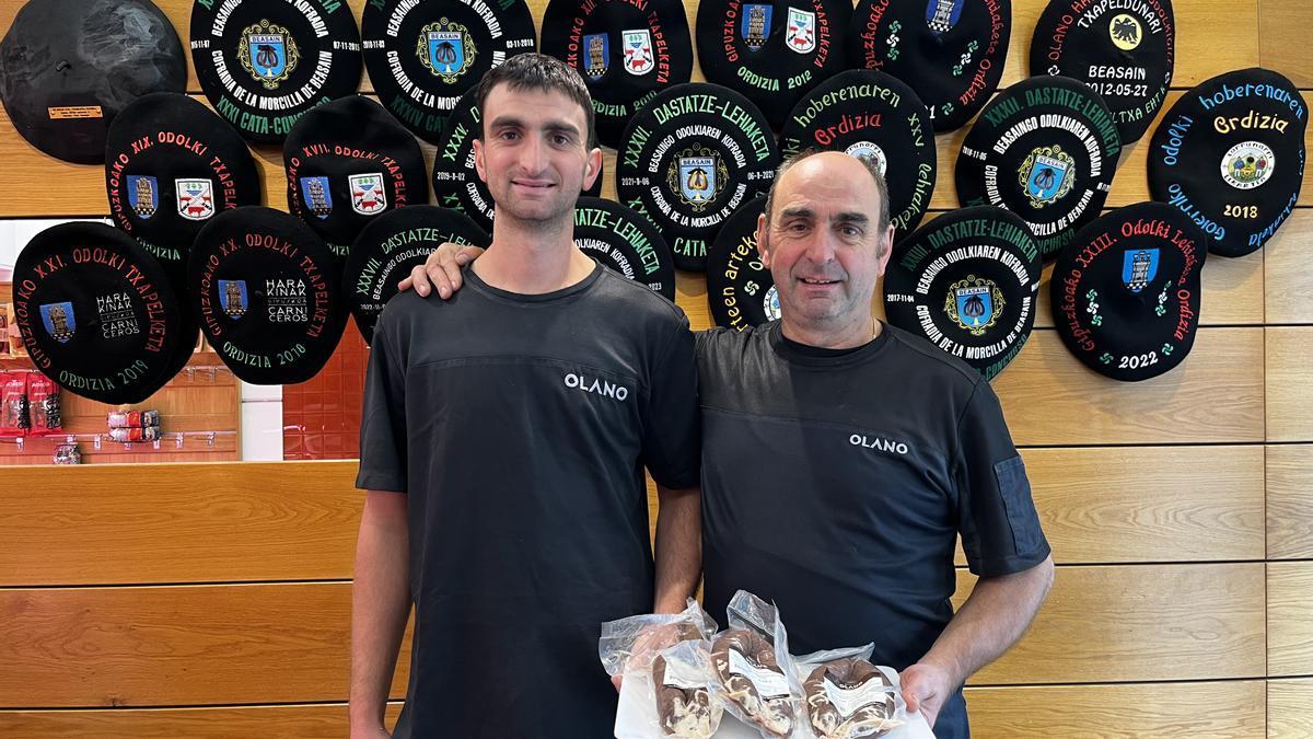 Xabier y Josema Olano, sosteniendo morcillas elaboradas por ellos, en su carnicería.